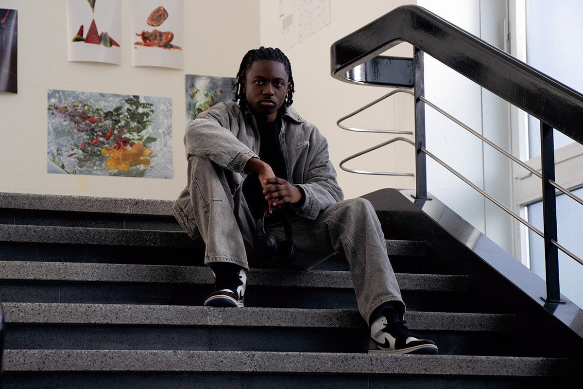 Photographe d'un homme assis sur des marches avec un casque a la main